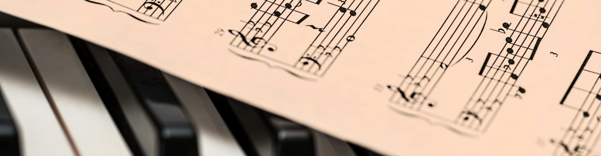 Black and white piano keys with a sheet of classical music creating a harmonious composition.